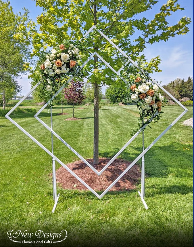 A Double Diamond Arch with 2 installments of florals, with large white roses and Large Toffee Roses,